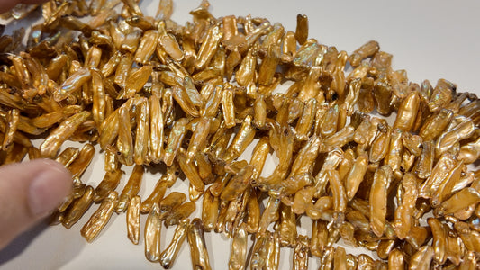 Golden Head Drilled Stick Pearls.  Lots of luster.  approx 5x20 graduated.  $10 a strand!