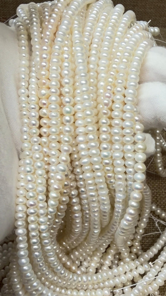 Button pearl strands draped over a white glove