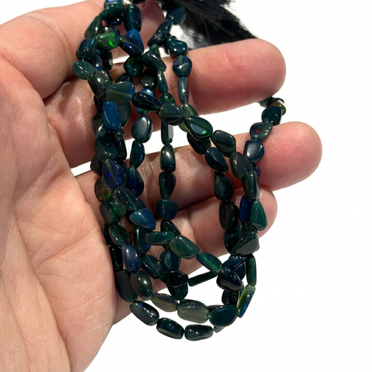 Black Ethiopian Opal Beads.  Green and blue flashes of intense color.  15" strands