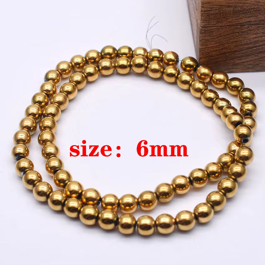 A coiled strand of shiny metallic gold 6mm round beads on a white background with a wooden block corner and red text reading 'size: 6mm'.