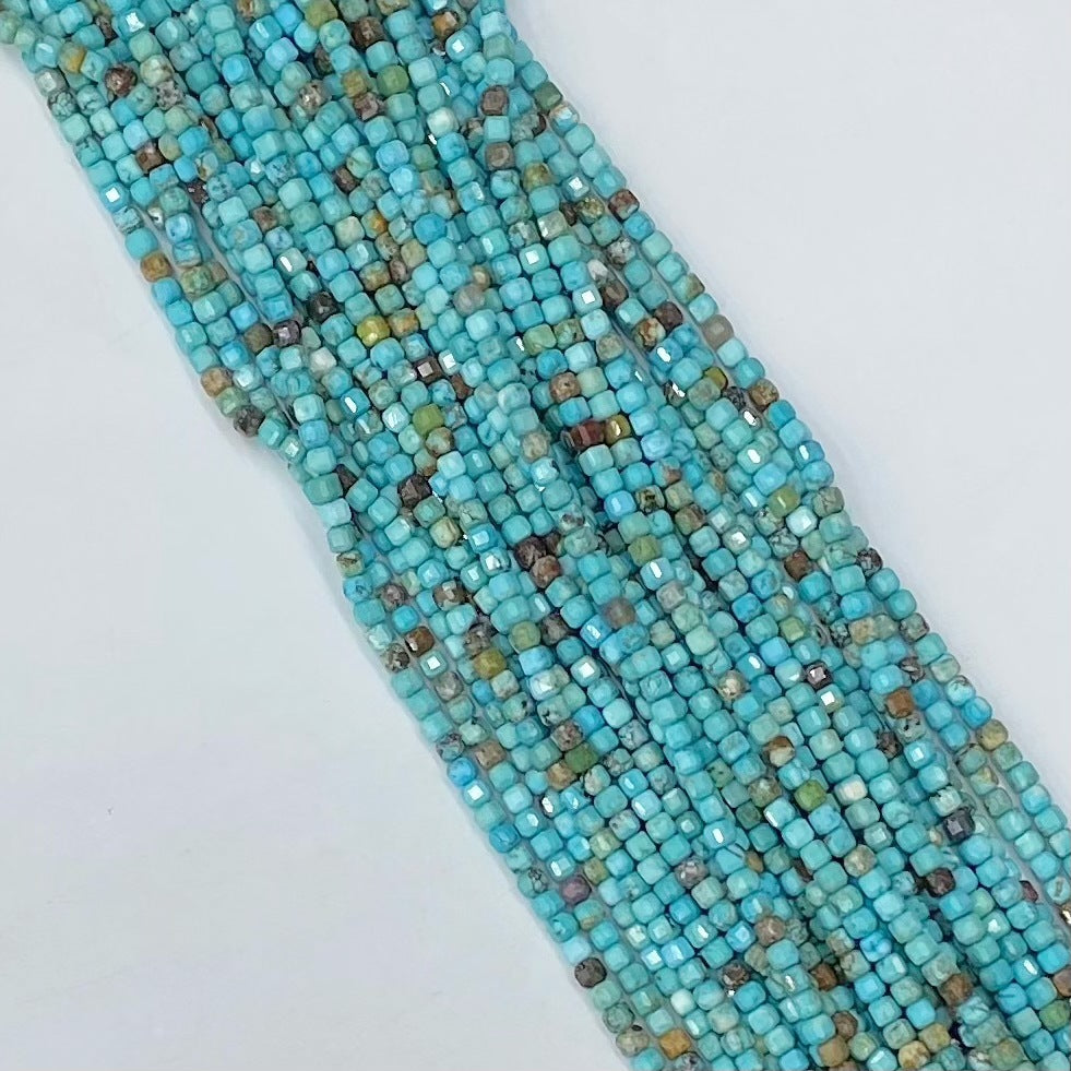 Multiple strands of faceted turquoise beads on a white background
