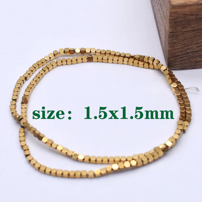 Gold metallic faceted round beads strung on a long thread, coiled on a white surface with green text reading 'size: 1.5x1.5mm