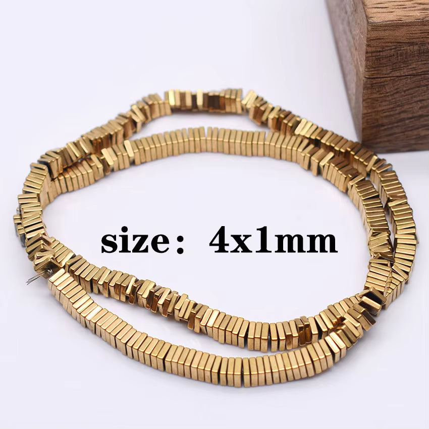 A coiled strand of small square  gold-toned beads on a white background, with overlaid text reading 'size: 4x1mm' and a wooden block corner visible at the top right.