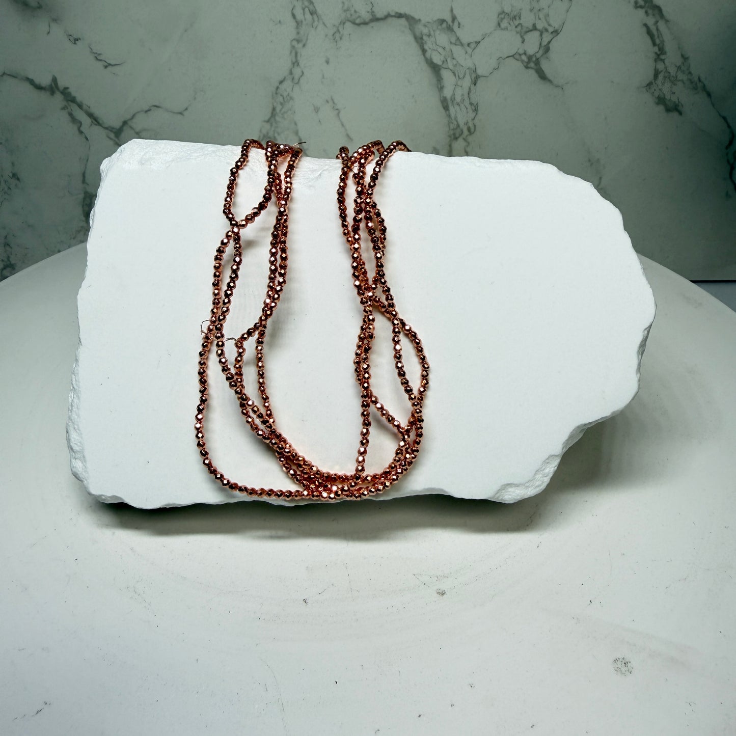 Hematite with Rose Gold PVD Finish.  Approx 15" Strands