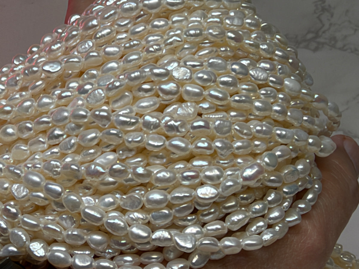 Close-up of strands of irregular baroque pearls white.
