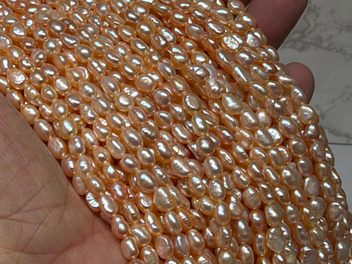 Close-up of strands of irregular baroque pearls champaign.