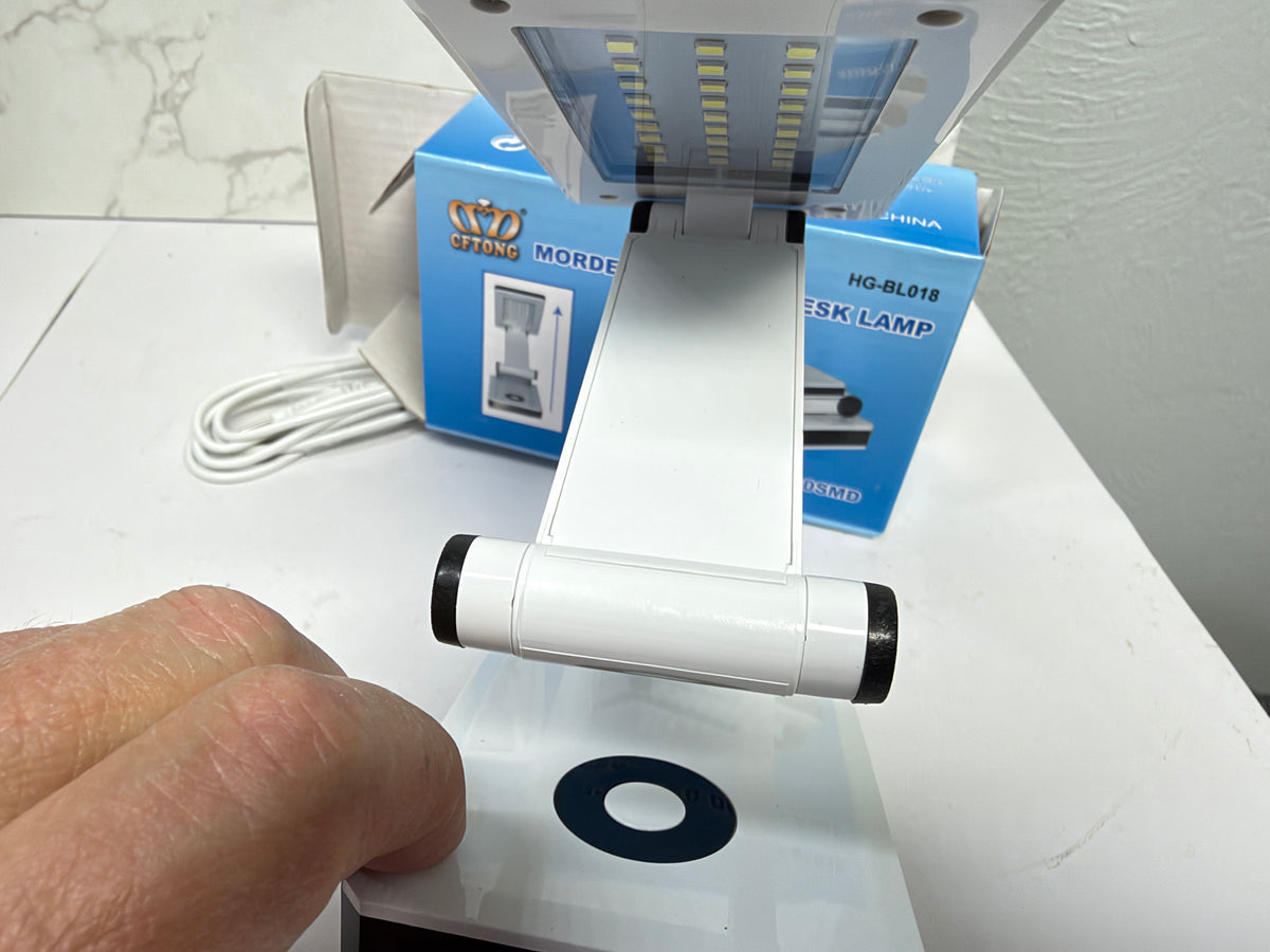 Front view of the white LED desk lamp showing the LED panel and circular touch control on the base.