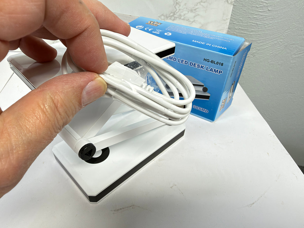 Close-up of the white USB power cable included with the folding LED desk lamp.