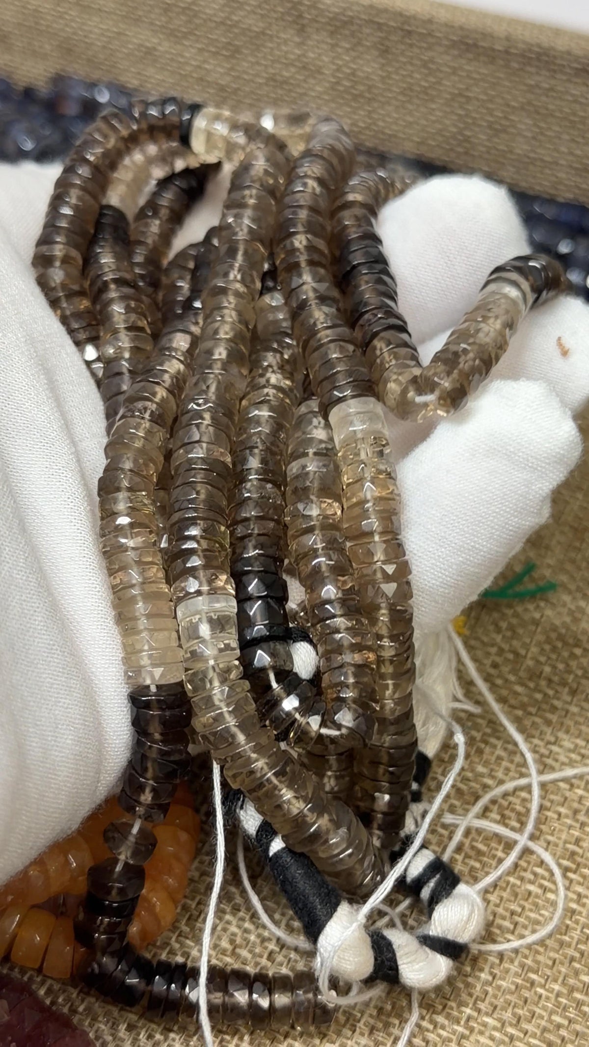 Ombre of Brown Tire faceted tire shaped beads on a white glove hand