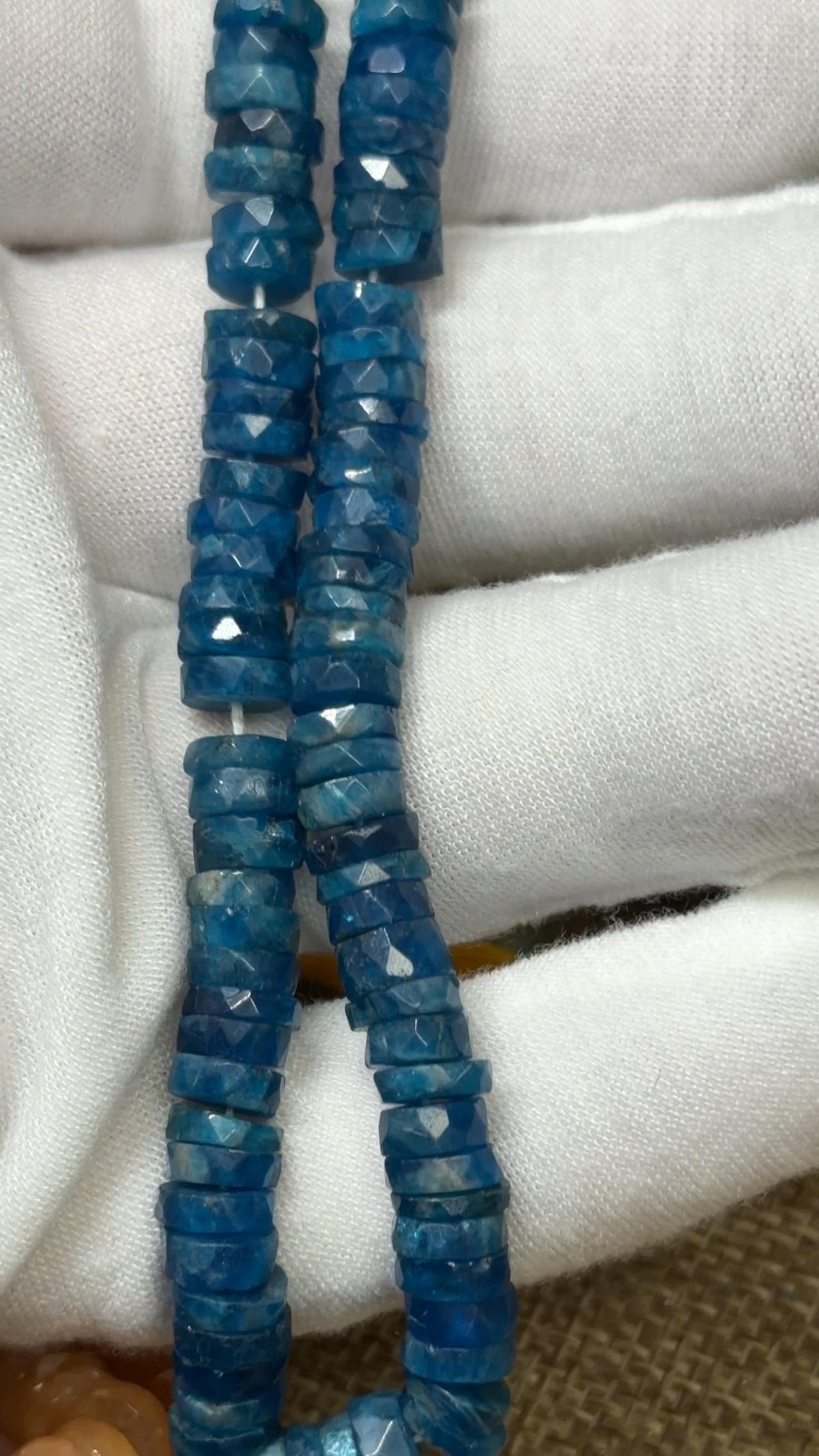 Blue Tire faceted tire shaped beads on a white glove hand