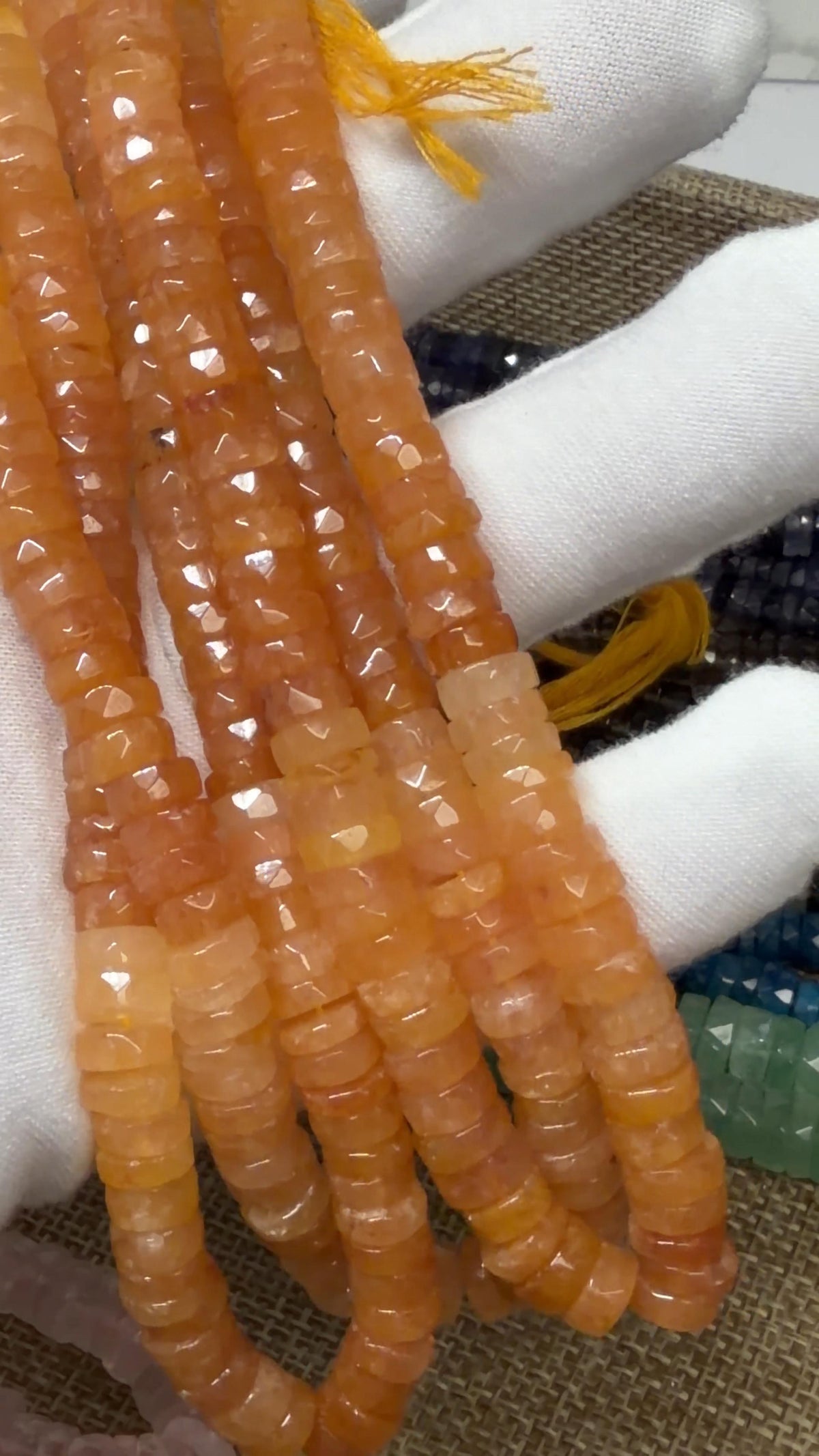 Orange Tire faceted tire shaped beads on a white glove hand