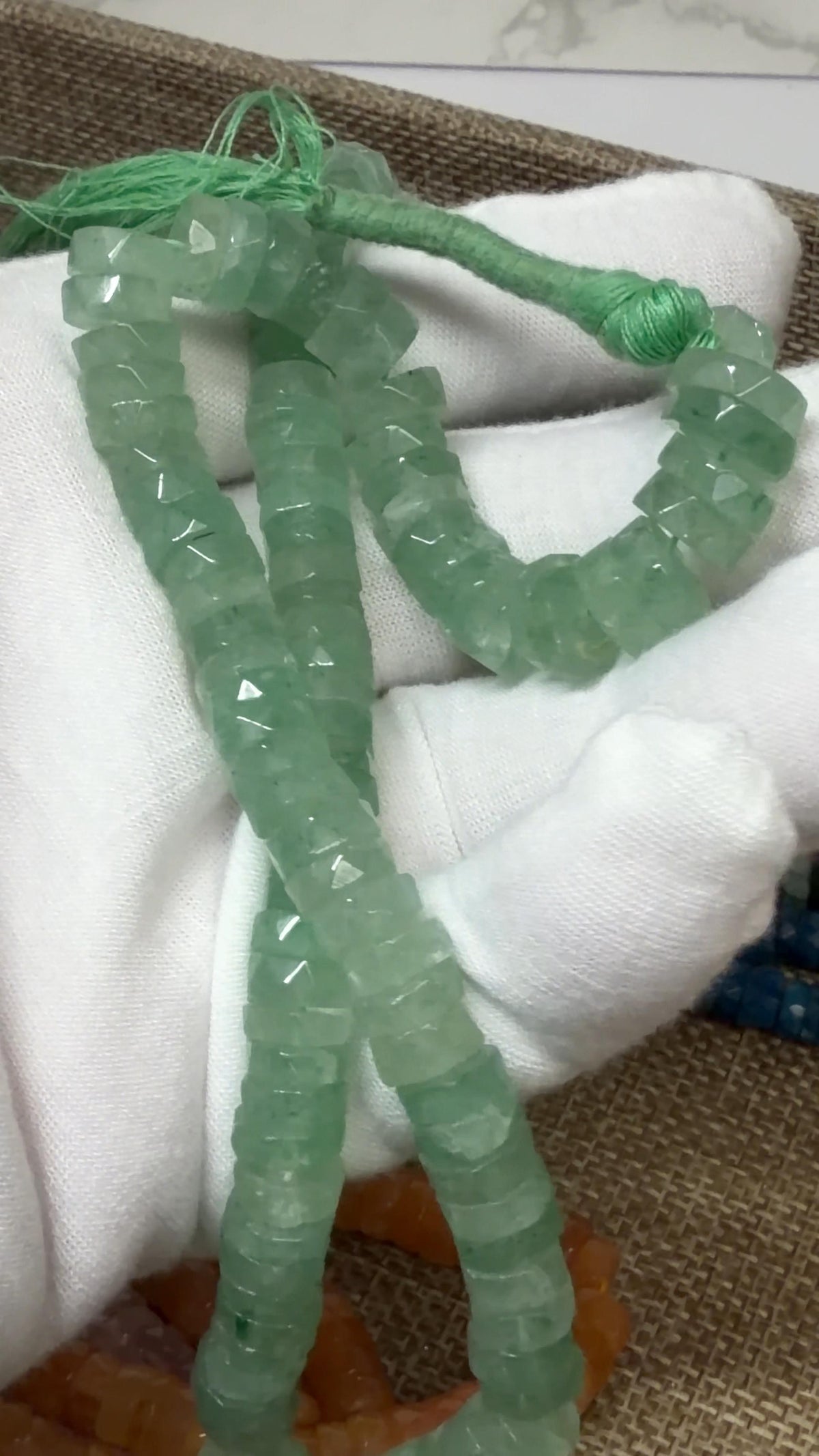 Light Green Tire faceted tire shaped beads on a white glove hand