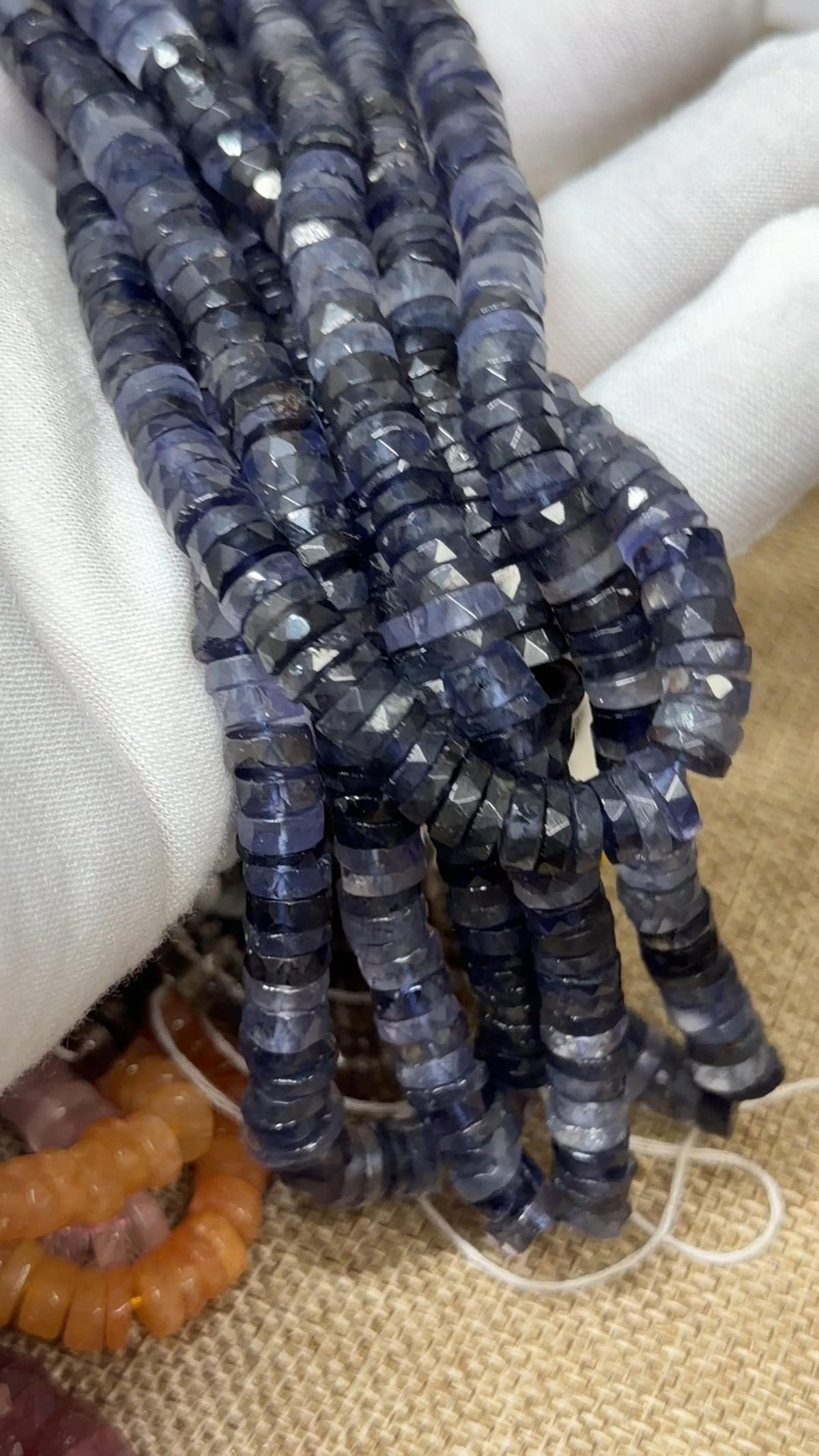 Purple/Blue Tire faceted tire shaped beads on a white glove hand
