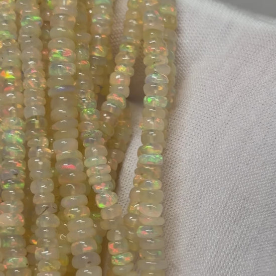 A video of Multiple strands of opal beads over a white glove