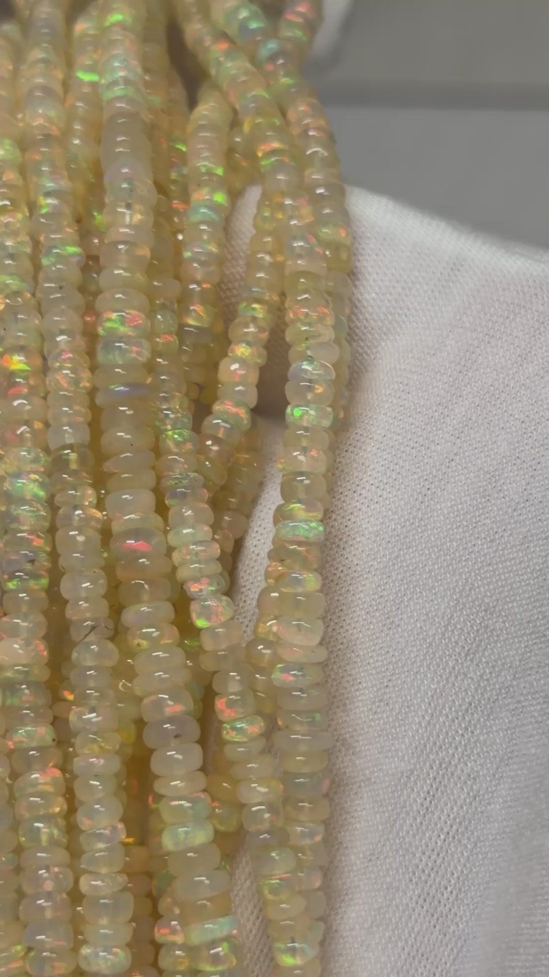 A video of Multiple strands of opal beads over a white glove